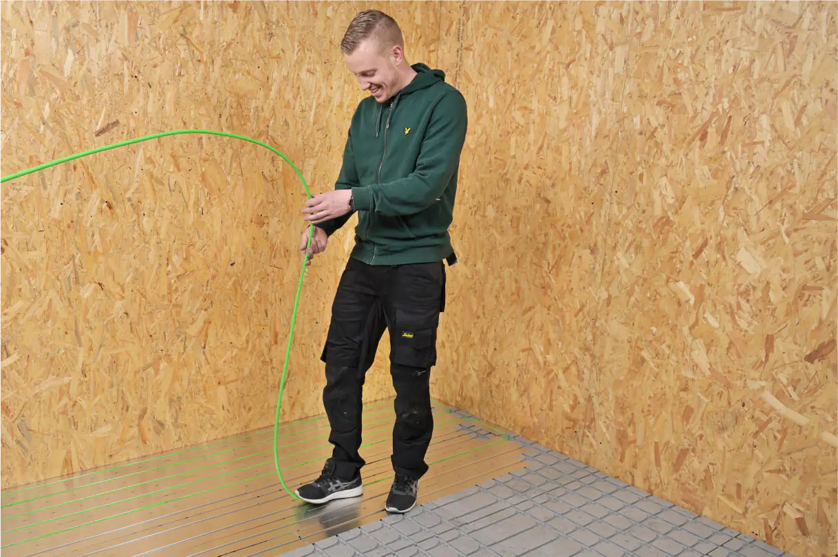 The installer is laying the pipes into the AluTherm.
